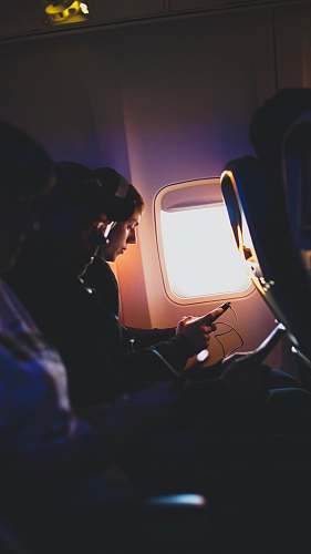airplane passenger photo of three people listening to music inside airplane on an airplane